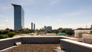 Ausblick von einer noch unbegrünten Dachterrasse Richtung Süden, in der Ferne: die Alpen