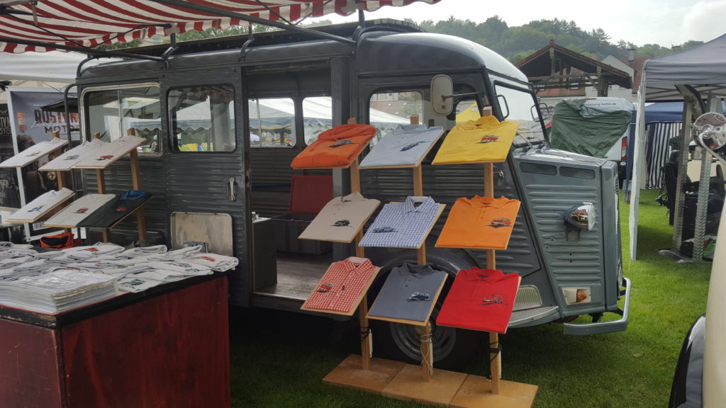 Stand mit Poloshirts vor Oldtimer-Lieferwagen