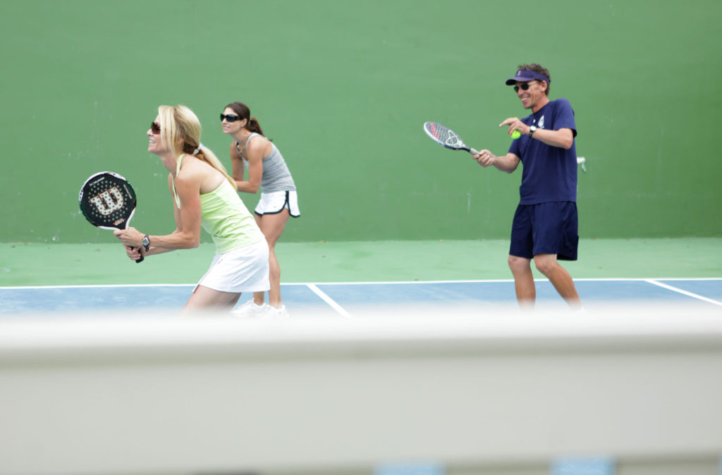 Ein Mann und zwei Frauen mit ihren Rackets auf einem Tennisplatz