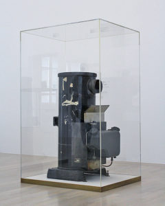 Ofen als Kunstobjekt von Joseph Beuys eingefasst in einem dicken Glaskasten im Lenbachhaus. 