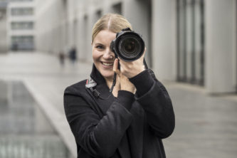 Junge Frau frontal mit Fotoapparat