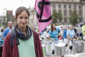 Portrait von Lisa Poettinger von Extinction Rebellion vor der Trommelgruppe Bateria Z