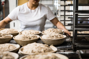 Eine Mitarbeiterin von Herrmannsdorfer schiebt Brot in den Ofen