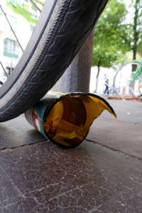 kaputte Bierflasche liegt direkt hinter einem Fahrradreifen