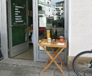 Vor der Eingangstüre steht ein Tisch auf dem allerlei Gläser mit Lebensmitteln drapiert sind