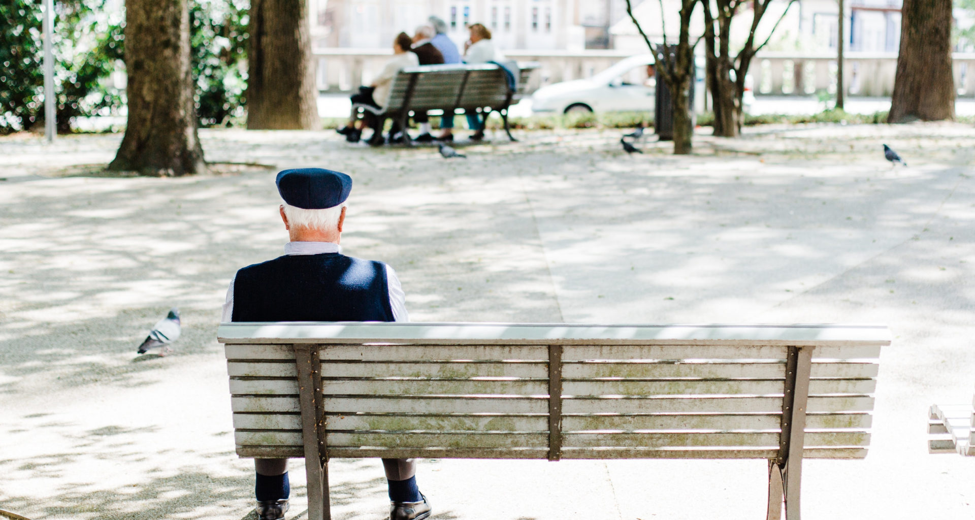 Älterer Mann sitzt auf einer Bank. Foto: Bruno Martins/Unsplash