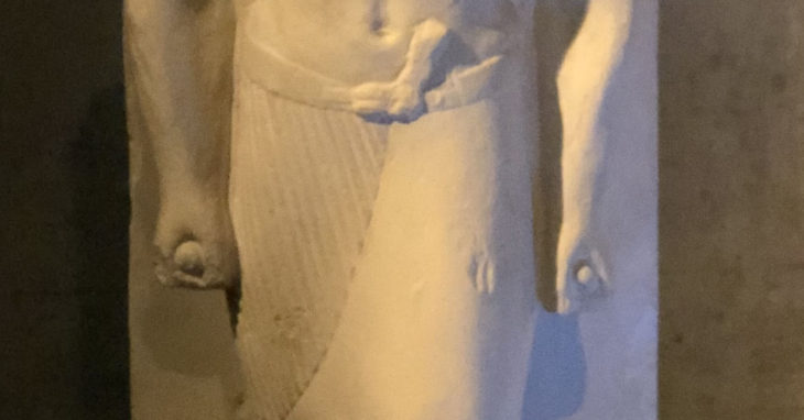 Detail von einer Stand-Schreitfigur im Ägyptischen Museum München. Zu sehen: Hände mit geballten Fäusten, darin ein Zepter, das die Figur als Lippi, Flötenspieler des Königs identifiziert. Selbsttet, Freiraum.t