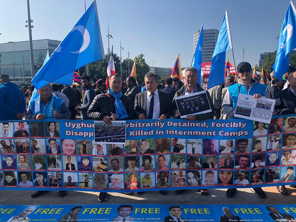 Blaue Protestwelle weltweit: Uiguren mahnen mit Oppositionsflaggen und Fotos von in chinesische Lager verschleppten Landsleuten das Drama ihres Volkes an. Eine Reportage von Friederike Albat