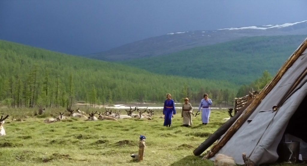 Frauen des mongolischen Nomadenstamms der Tsaatan passieren eine Rentierherde in der SteppeRentiere und