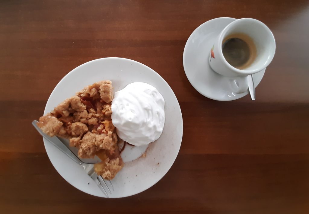Nachtisch: Espresso und ein Stück Apfelkuchen mit veganer Sahne auf Holztisch im Katzentempel München - Beitrag und Foto: Carmen Weber
