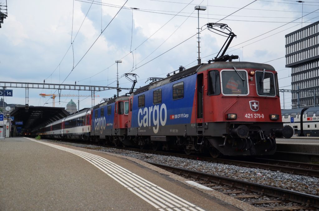 ein roter mit blauen Elementen laktierter Zug der Schweizer Bahn steht am Gleis 14